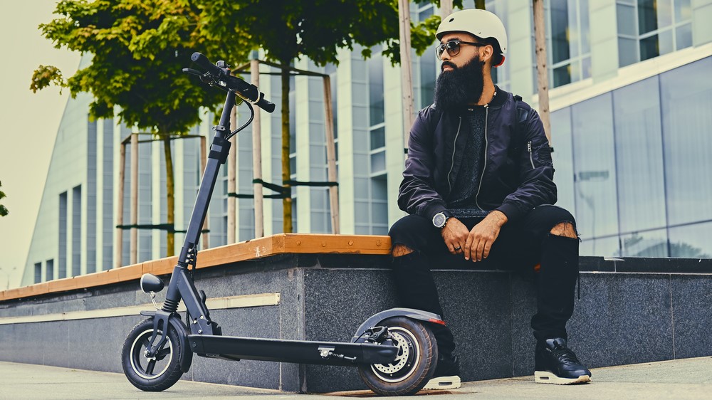 Man wearing helmet with electric scooter