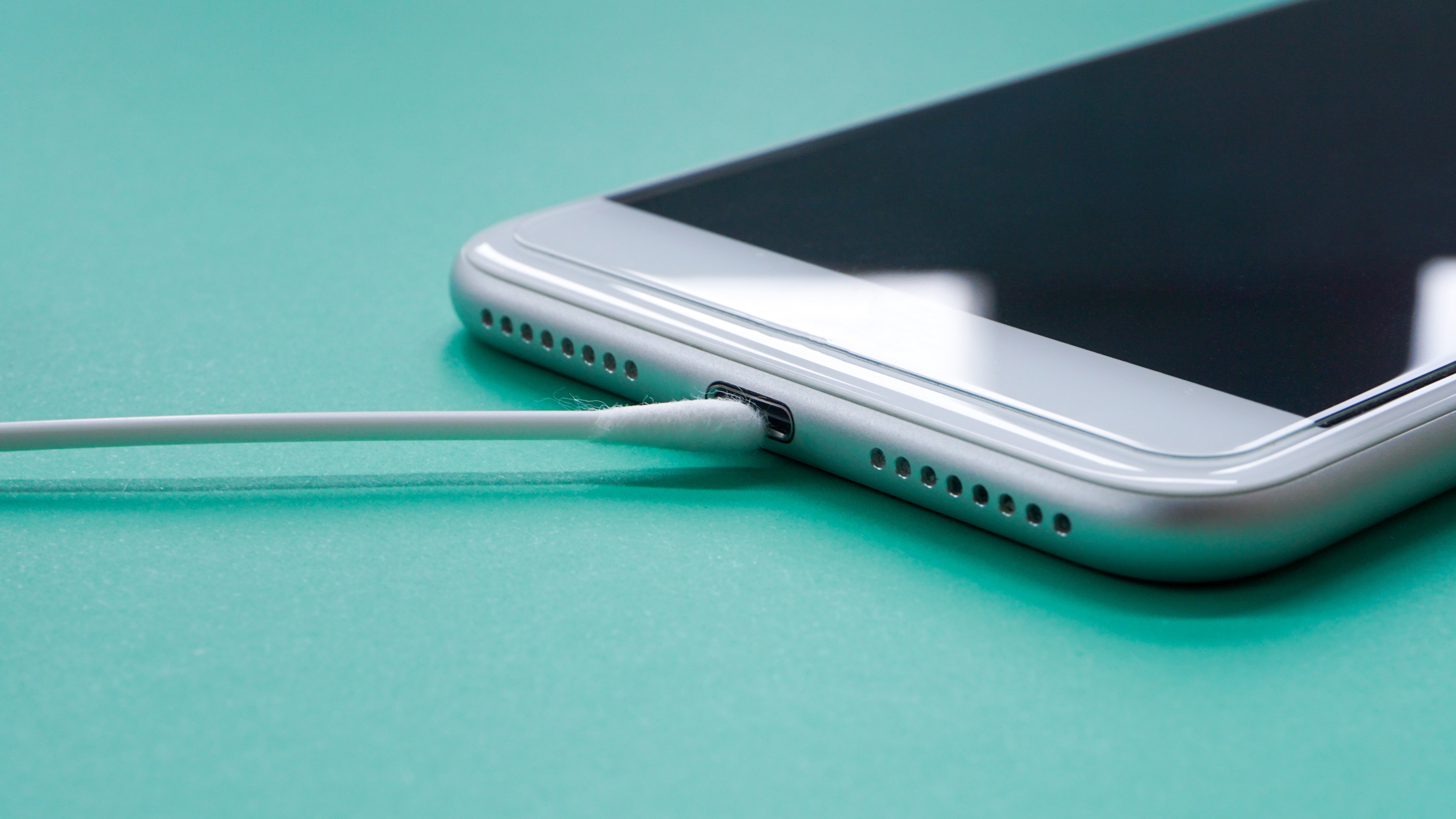 Cotton bud being used to clean a phone charging port