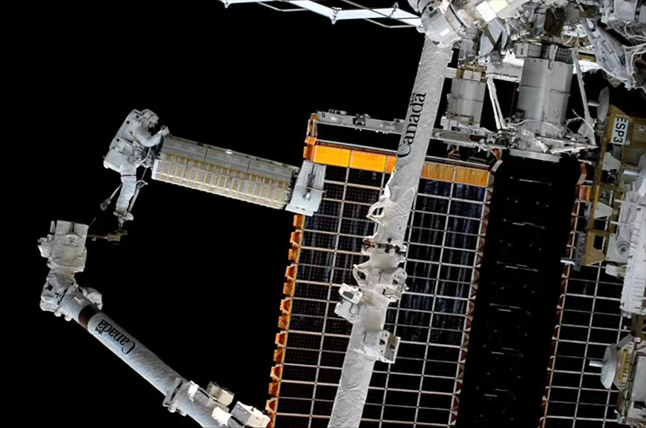 NASA astronauts deploy roll-out solar array while spacewalking outside space station