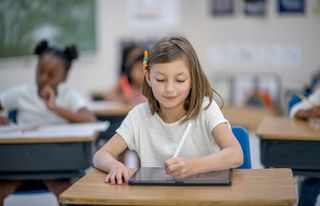 Back to school discounts 2022: girl sitting in school classroom