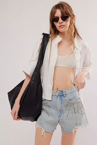 a model wears embellished denim cutoff shorts