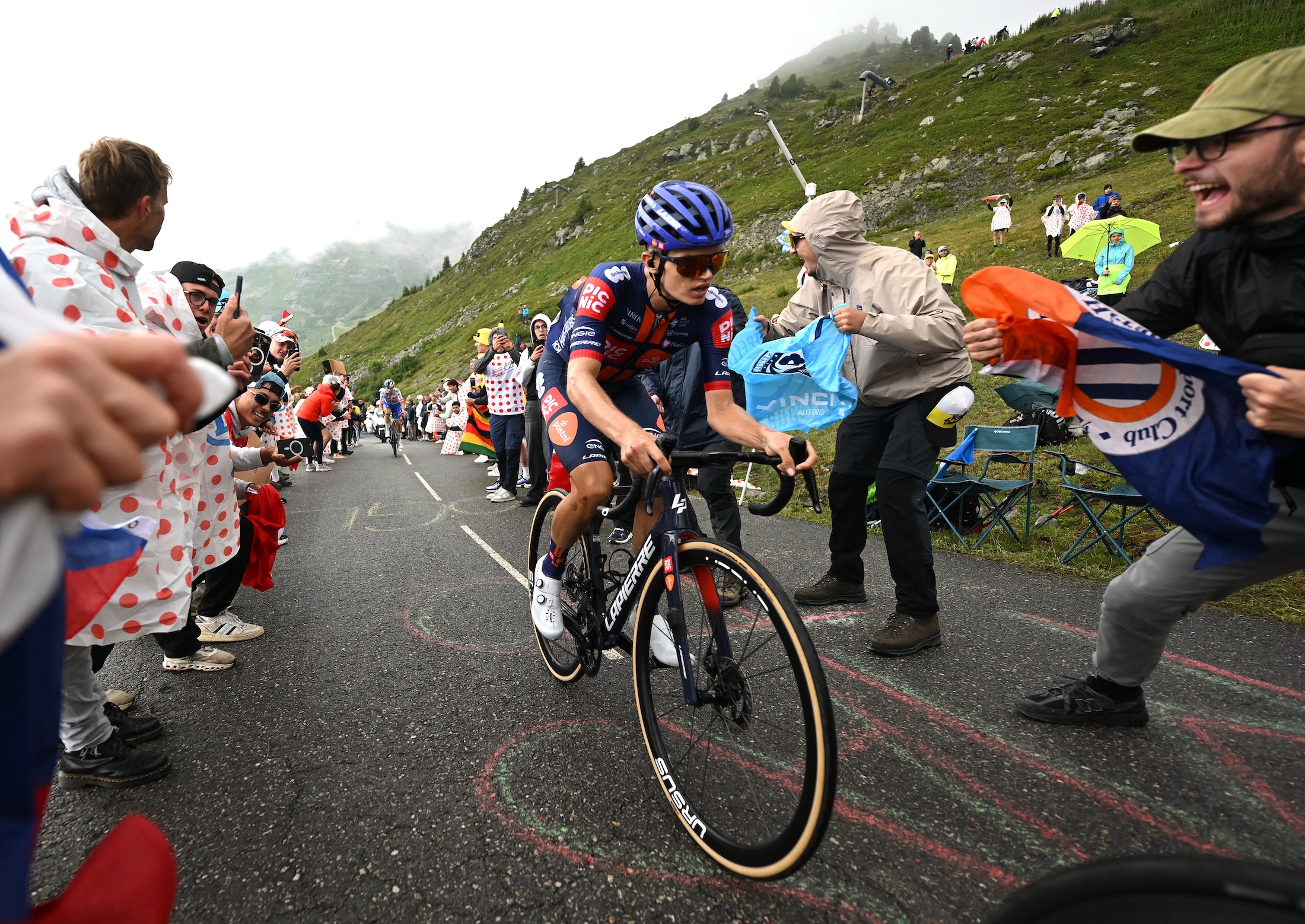 COURCHEVEL - COL DE LA LOZE, FRANCE - JULY 24: Oscar Onley of Great Britain and Team Picnic PostNL competes climbing the Col de la Loze while fans cheer during the 112th Tour de France 2025, Stage 18 a 171.5km stage from Vif to Courchevel - Col de la Loze 2298m / #UCIWT / on July 24, 2025 in Courchevel - Col de la Loze, France. (Photo by Tim de Waele/Getty Images)