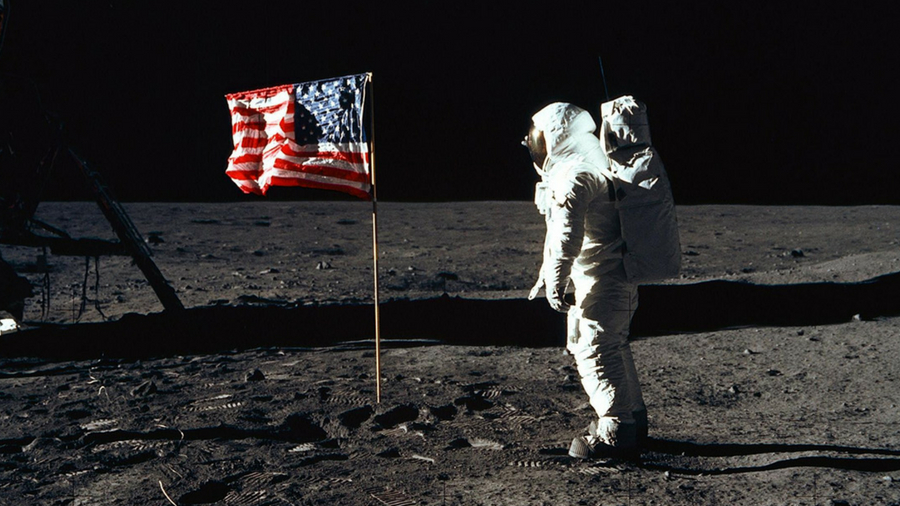 Image of an astronaut standing by an American flag on the moon