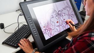 The best drawing tablets for animation, represented by a woman drawing on a tablet