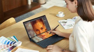 A person drawing on a Asus ZenBook Duo 14 laptop