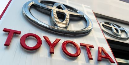 Toyota logo on side of building with "Toyota" spelled out in red lettering