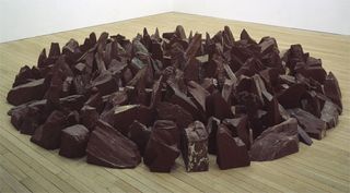 Richard Long, Red Slate Circle: "A group of people sit on the beach with two bags but also a group of people are on the beach with blankets. Reminds me of people on a beach, walking and laying on blankets."
