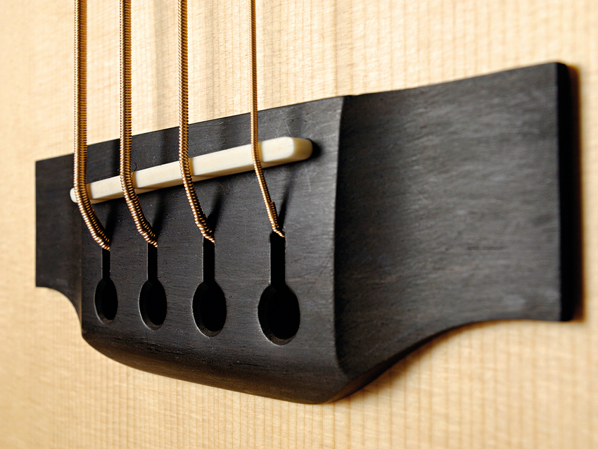 Keyhole-shaped slots help anchor the ball ends of the strings