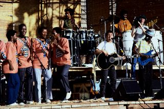 Paul simon performs with his band on the graceland tour in 1987