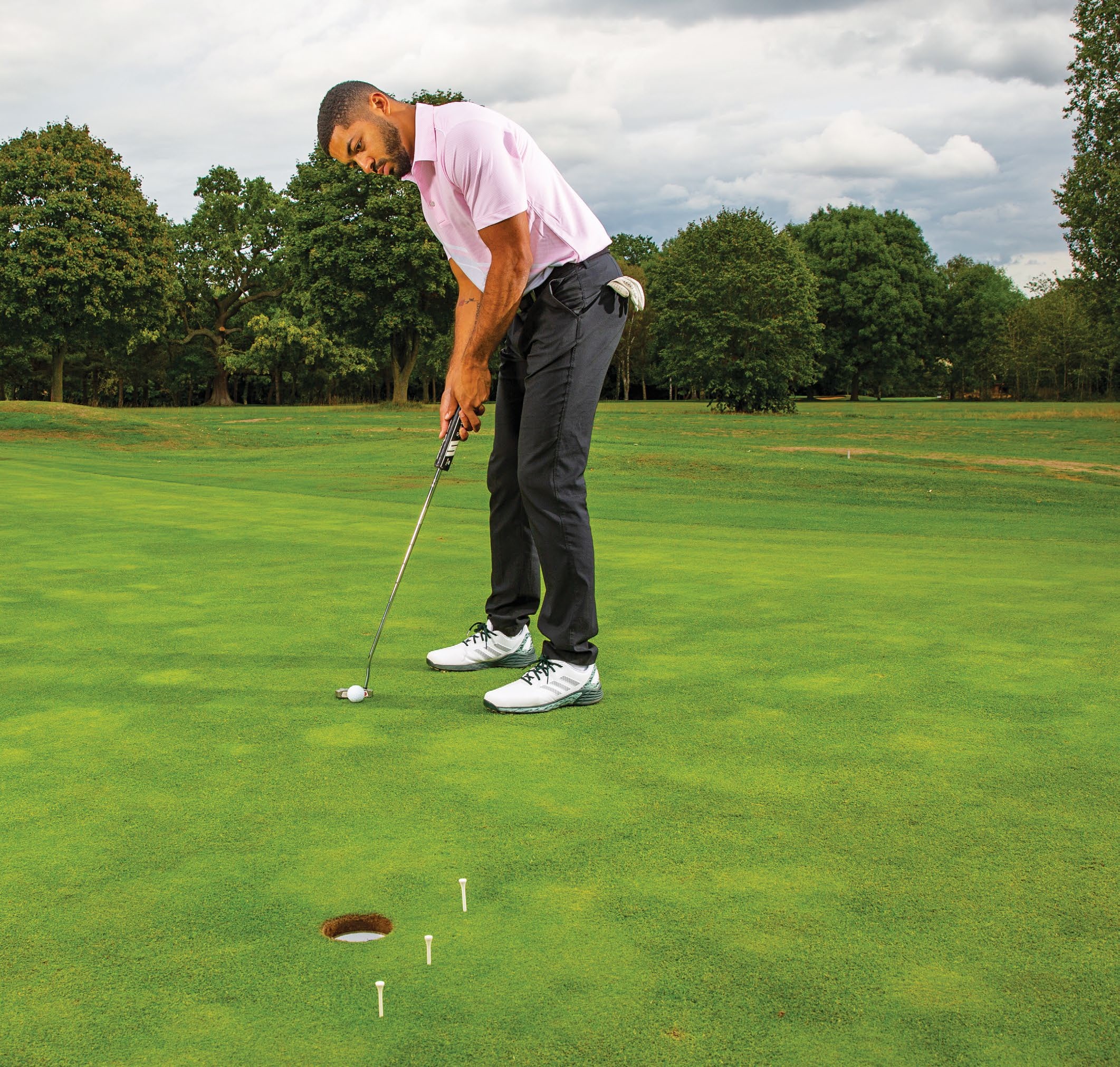 Trey Niven demonstrating a drill where he hits three putts from the same location, at different speeds, in order to understand how hard to hit short putts