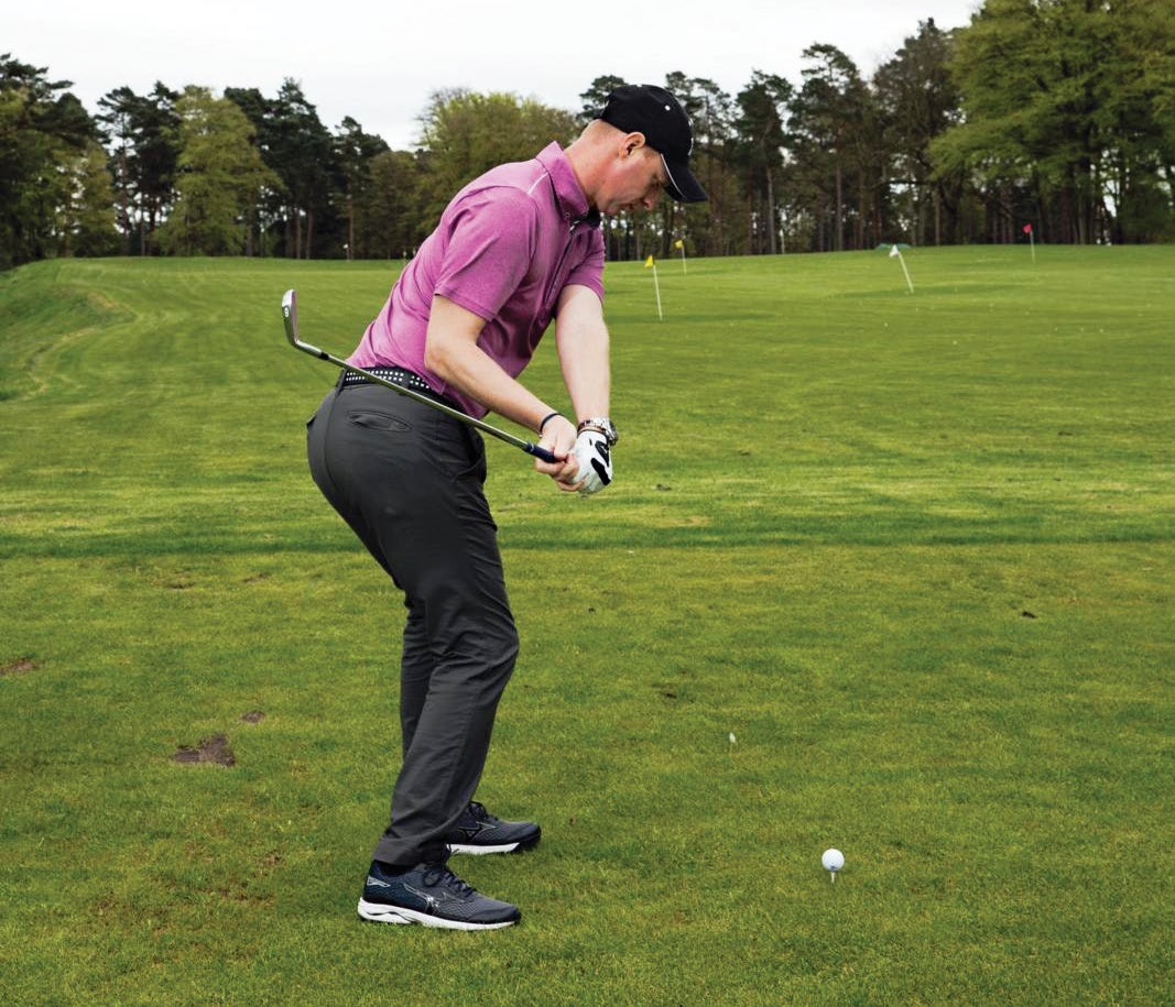 Ged Walters demonstrating a sequencing drill for the golf swing, with the hips rotated towards the target while the sternum still points down towards the golf ball in the downswing