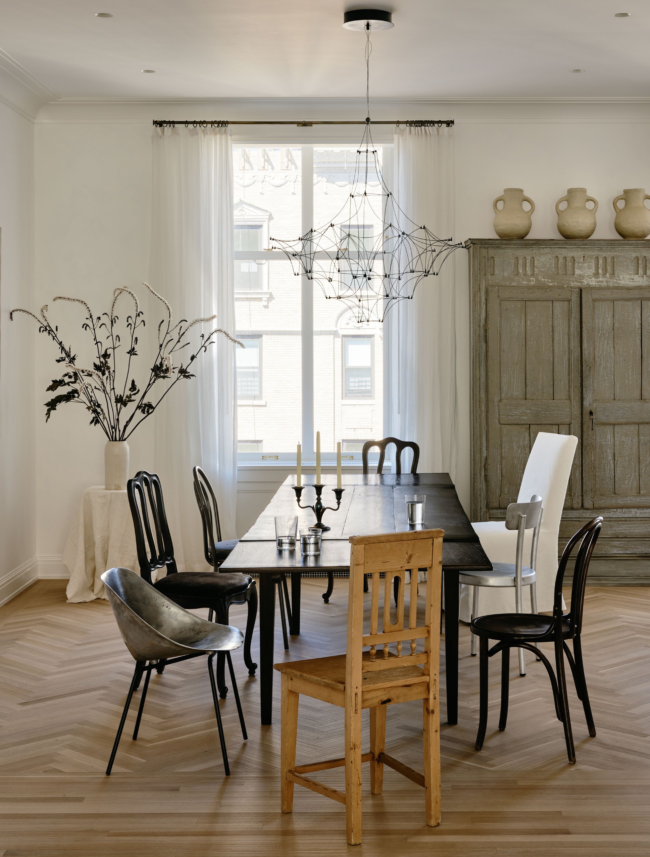 a dining room with mismatched antique dining chairs