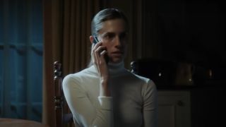 Allison Williams, talking on the phone in a white shirt in Get Out