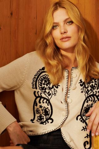 iceland fashion - woman wearing cream cardigan with black floral embroidery