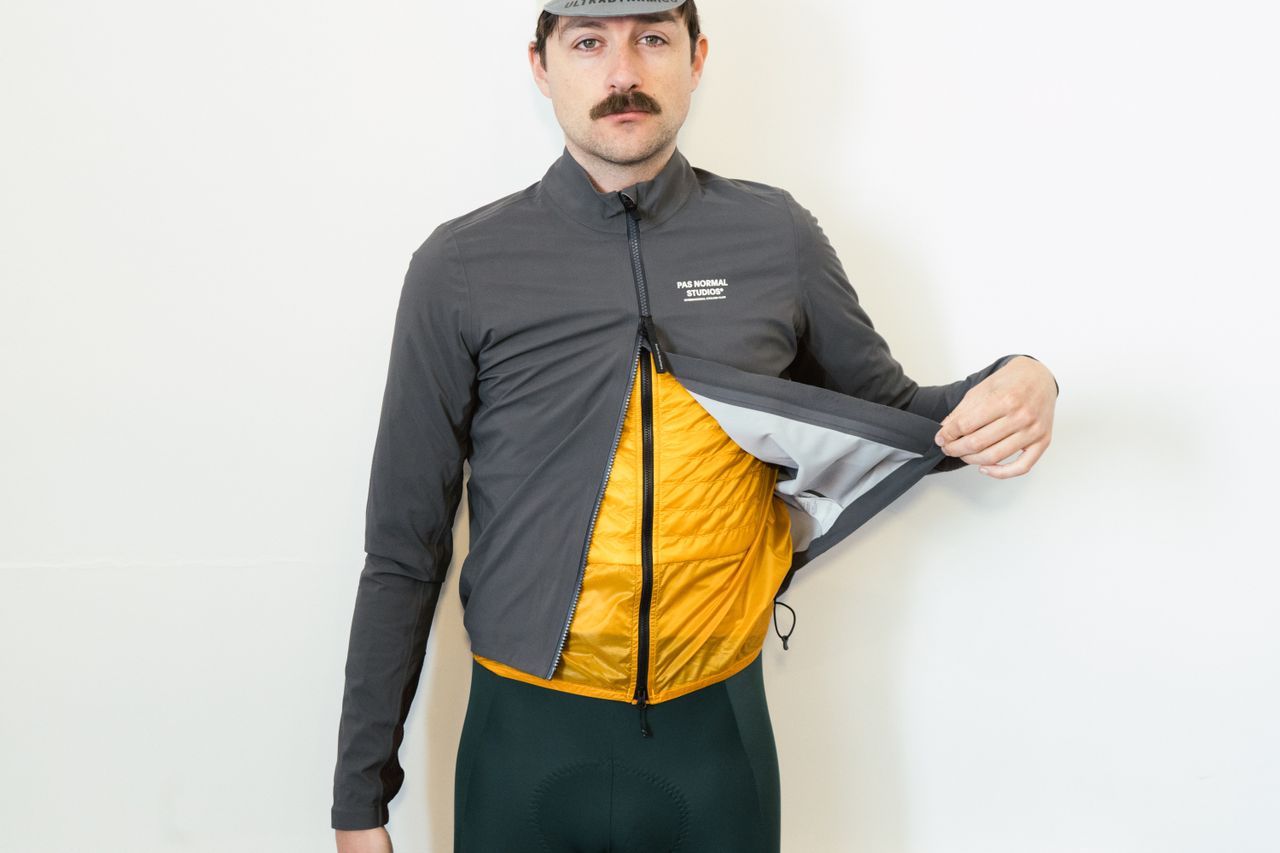 A white man in a grey jacket simulates different riding positions