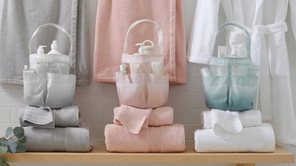 Three shower caddies on folded towels