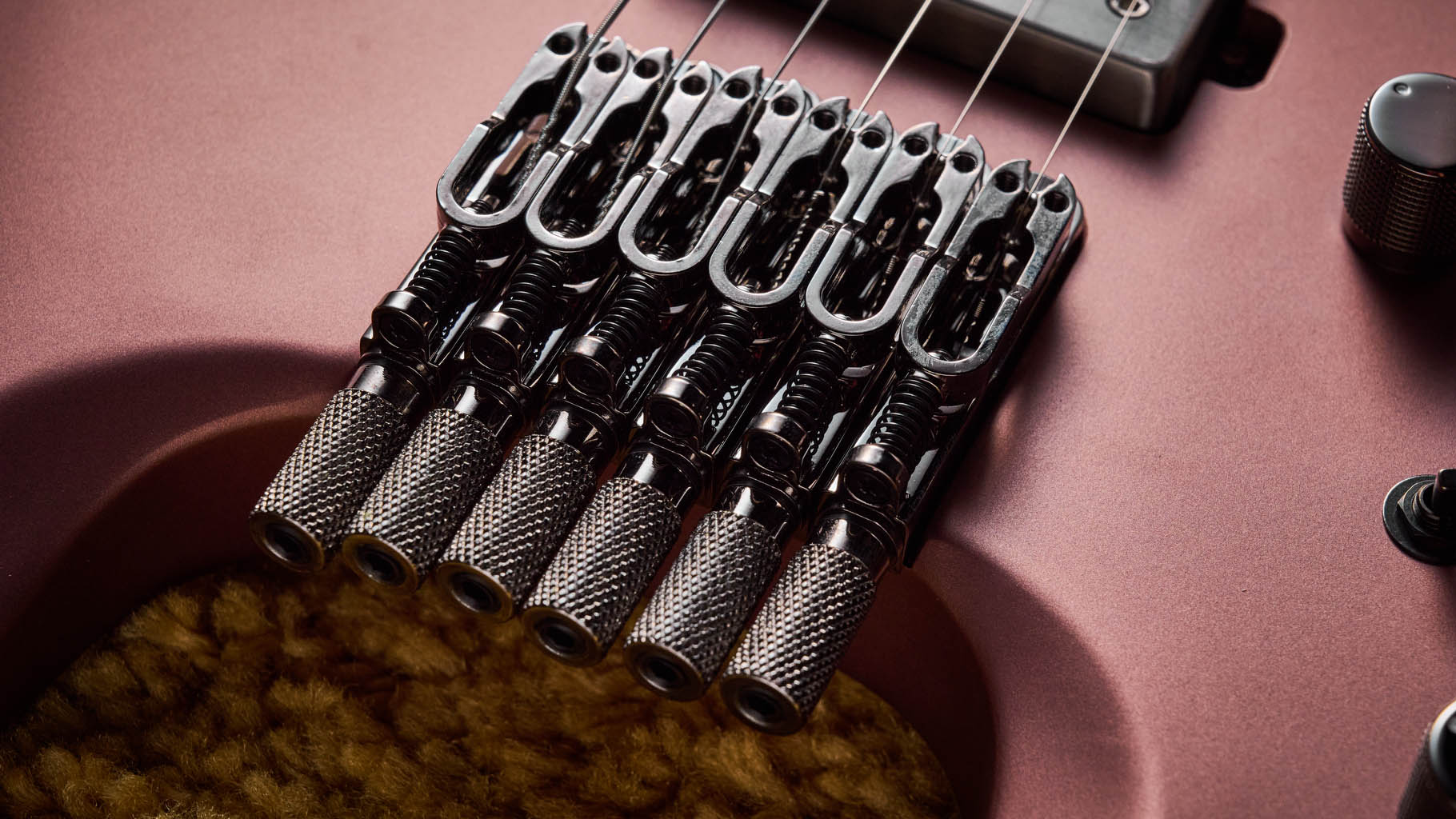 Ibanez Q54W: the headless electric guitar is finished in Copper Metallic Matte and photographed against a thick light-tan colored carpet.