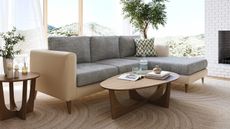 mid-century style living room with white brick fireplace, potted plant, and two-tone sofa with beige frame and gray seat cushions