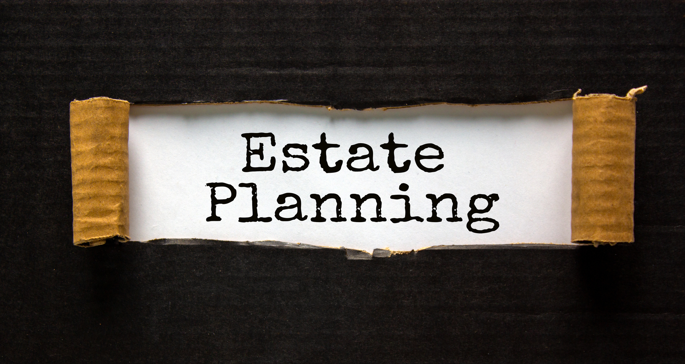 The text 'estate planning' appearing behind torn black paper. Business concept.
