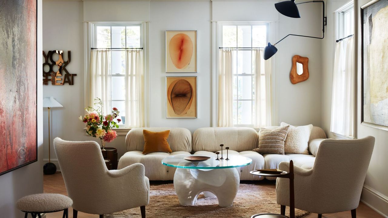 living room with white sectional sofa glass coffee table and two occasional chairs