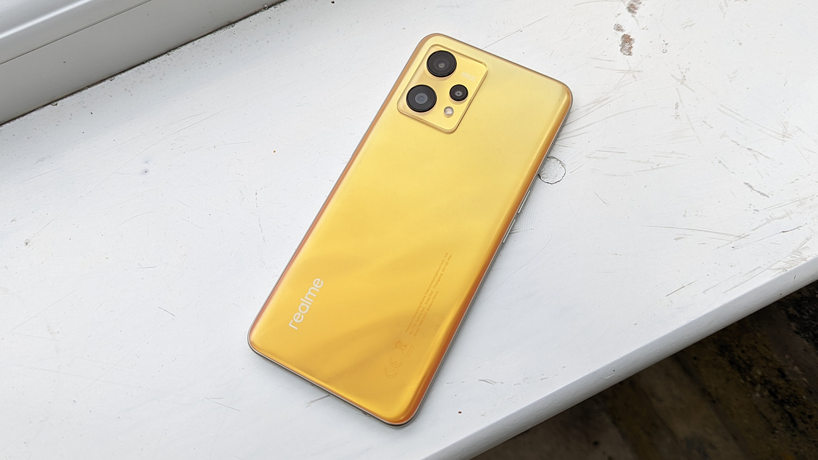 The Realme 9 lying face down on a window sill