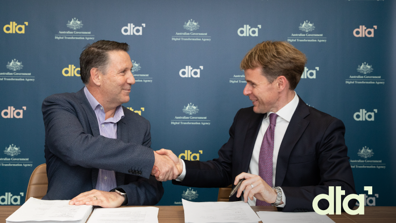 Chris Fechner, DTA CEO, and Nicholas Flood, Managing Director of IBM Australia shaking hands after signing the agreement