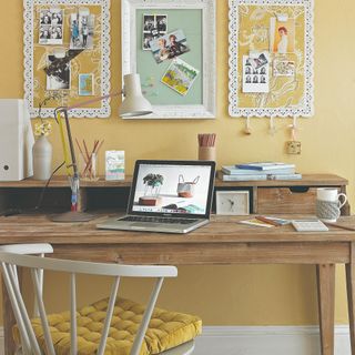 Yellow-painted home office with a desk and laptop