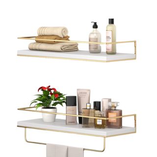 Two white wall shelves with gold borders and toiletries in them