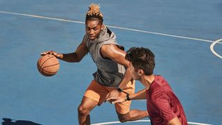 Bästa priser och erbjudanden på Fitbit: En tjej och en kille spelar basket med en varsin Fitbit runt handleden.