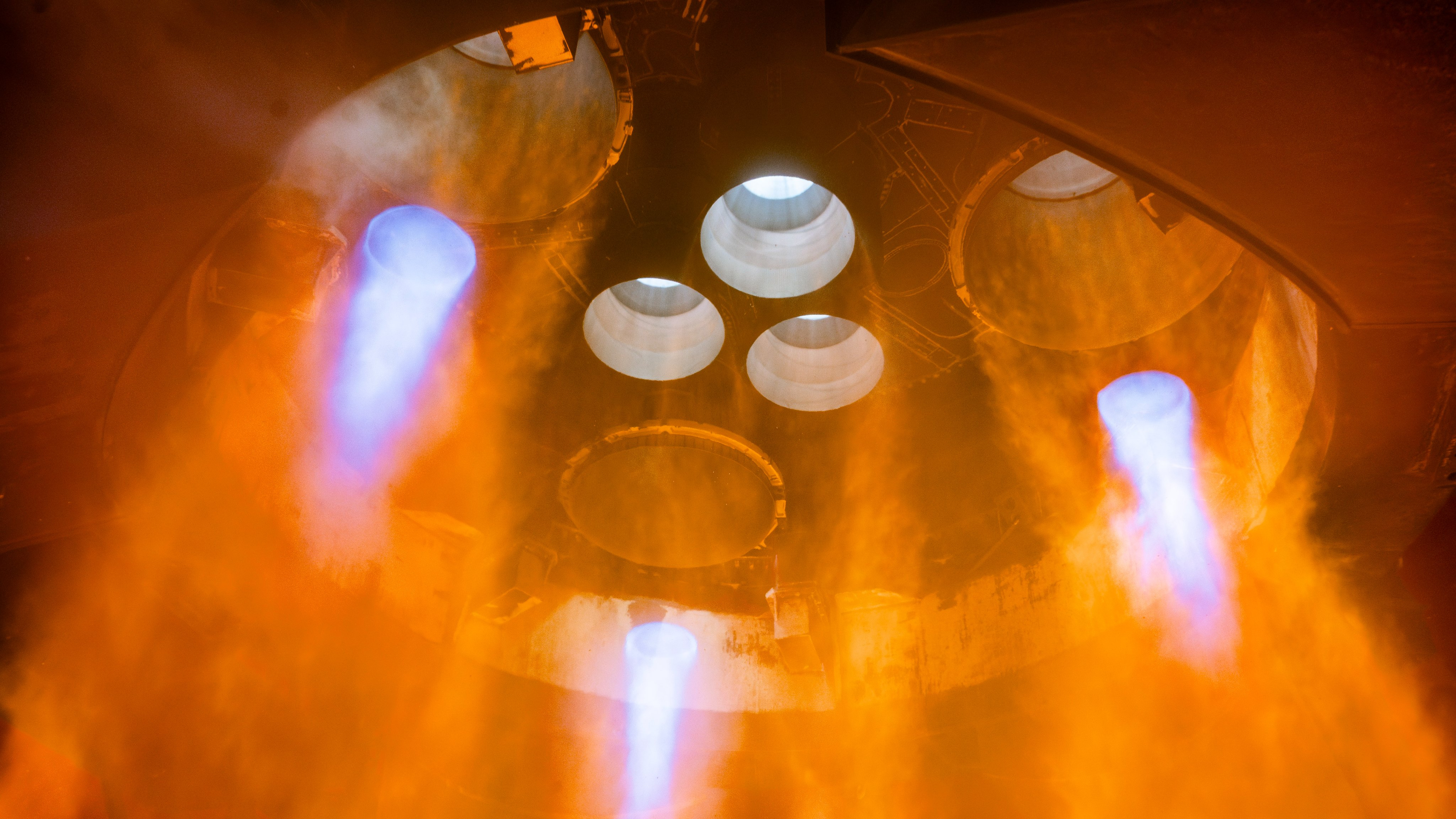 up-close view of six rocket engines firing on a test stand