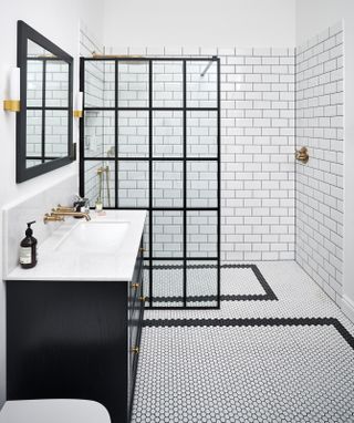 a bathroom with a mosaic floor tile border