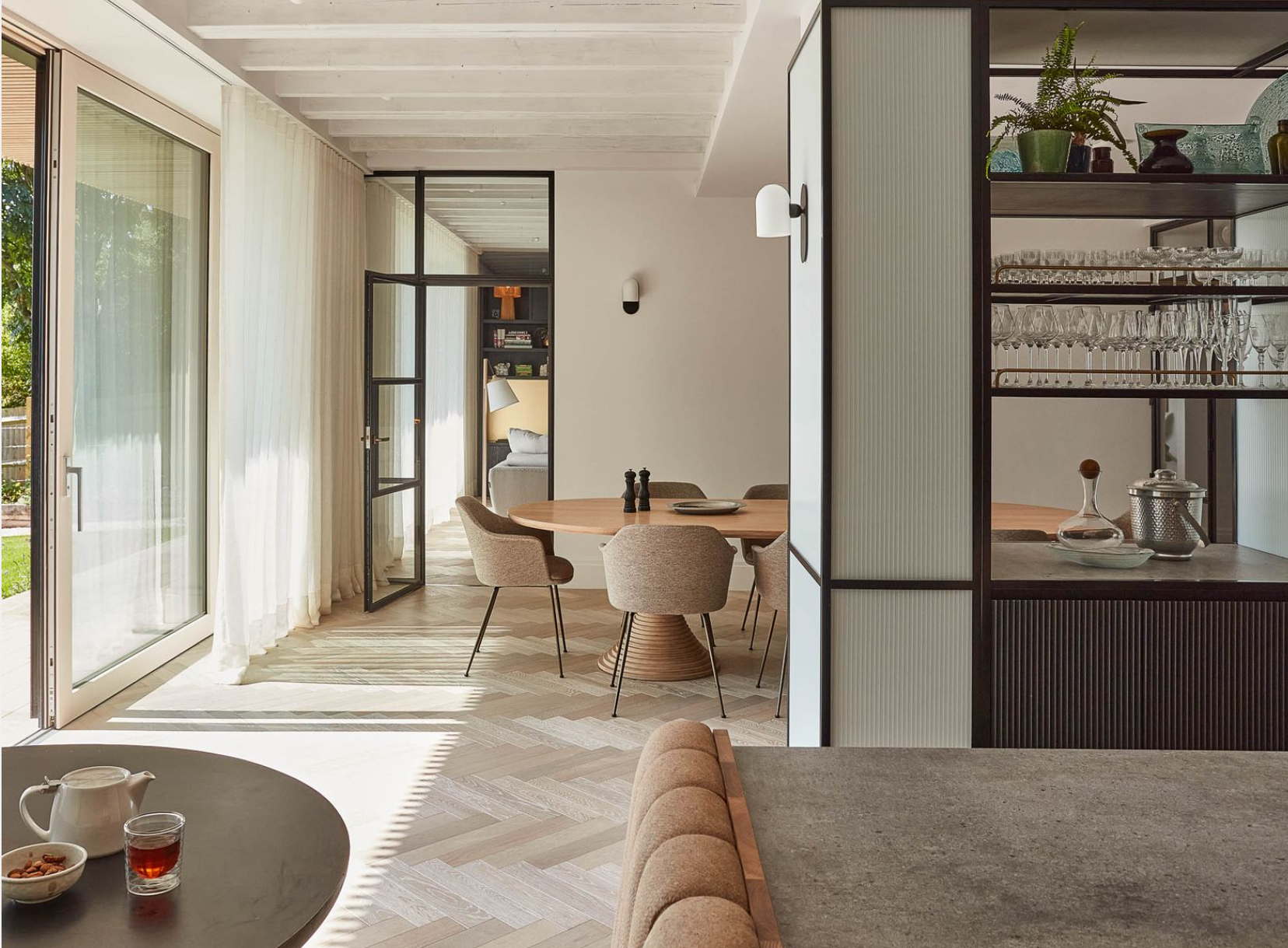 mid-century modern open plan dining space with sliding doors and drinks cabinet partition wall