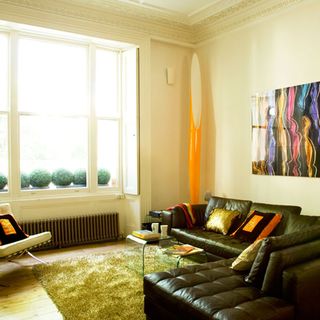 living area with green sofa and wall painting