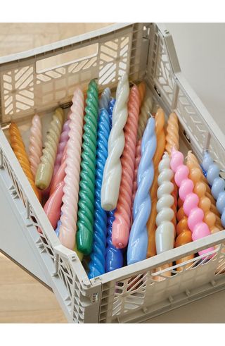 spiral tapered candles in a storage crate which come in a mix of colors and styles