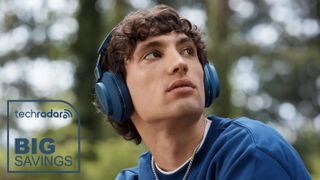 A young man wearing an Ocean Blue pair of Bowers & Wilkins Px7 S2e headphones