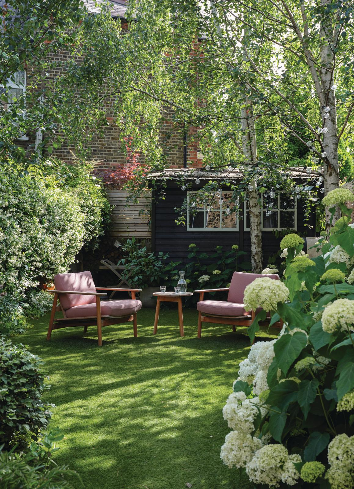 Suzy Hoodless garden with lots of flowers and outdoor furniture