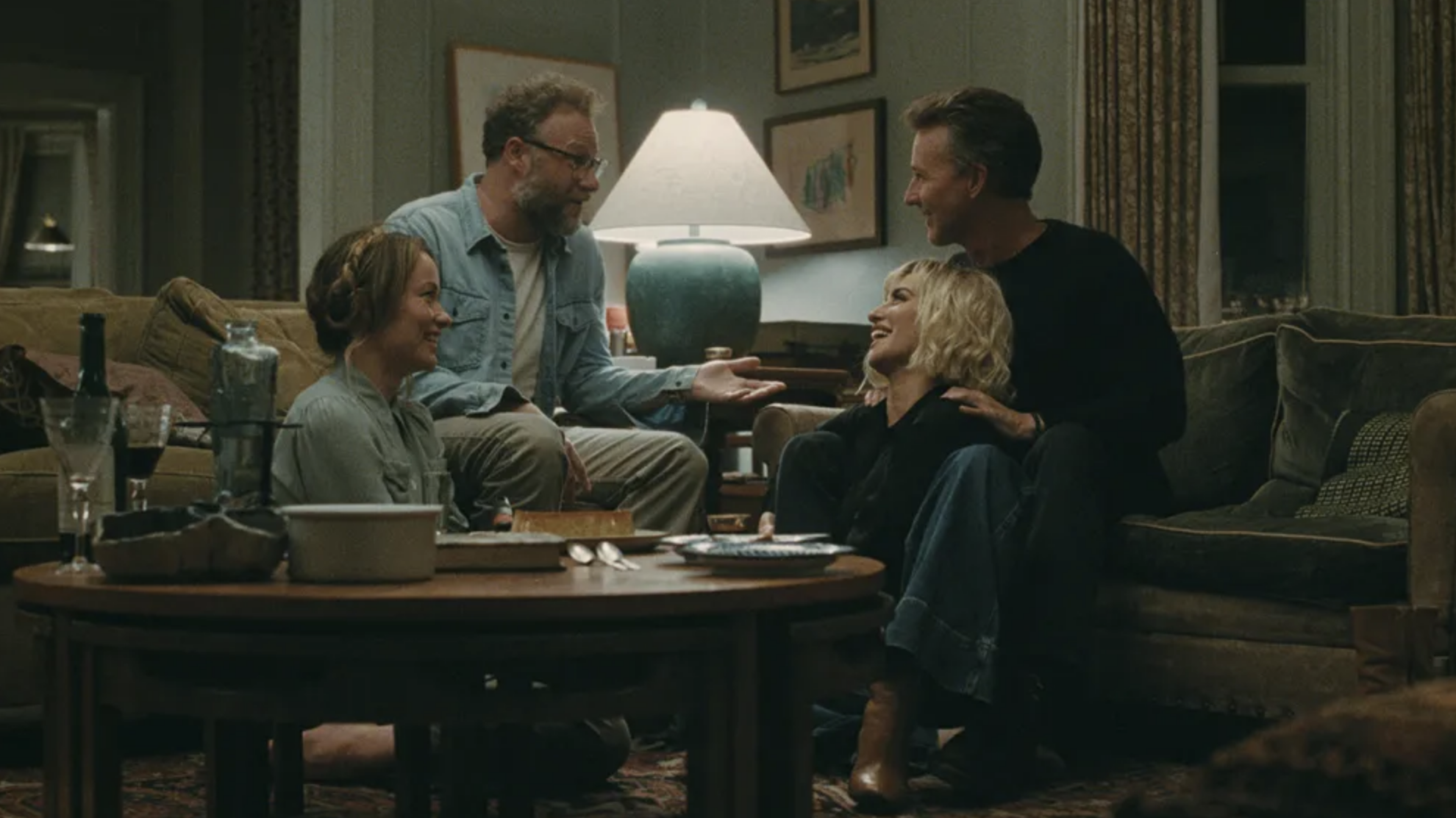 Olivia Wilde, Seth Rogen, Edward Norton, and P&amp;eacute;nelope Cruz sit talking in a living room.