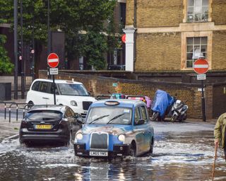 London cab and cars in flooded road in central london last august