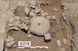 A millstone, likely buried as an offering to the gods, that the archaeologists found in the courtyard.