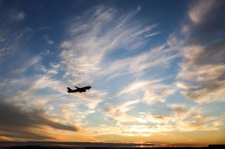 A plane flying at sunset