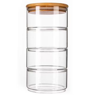 Four glass containers are stacked on top of each other with a bamboo lid