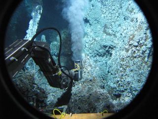 The research submarine Alvin reaches with its mechanical arm to a high-temperature black smoker at the Endeavour Segment, Juan de Fuca Ridge, to study methanogenic microbes.