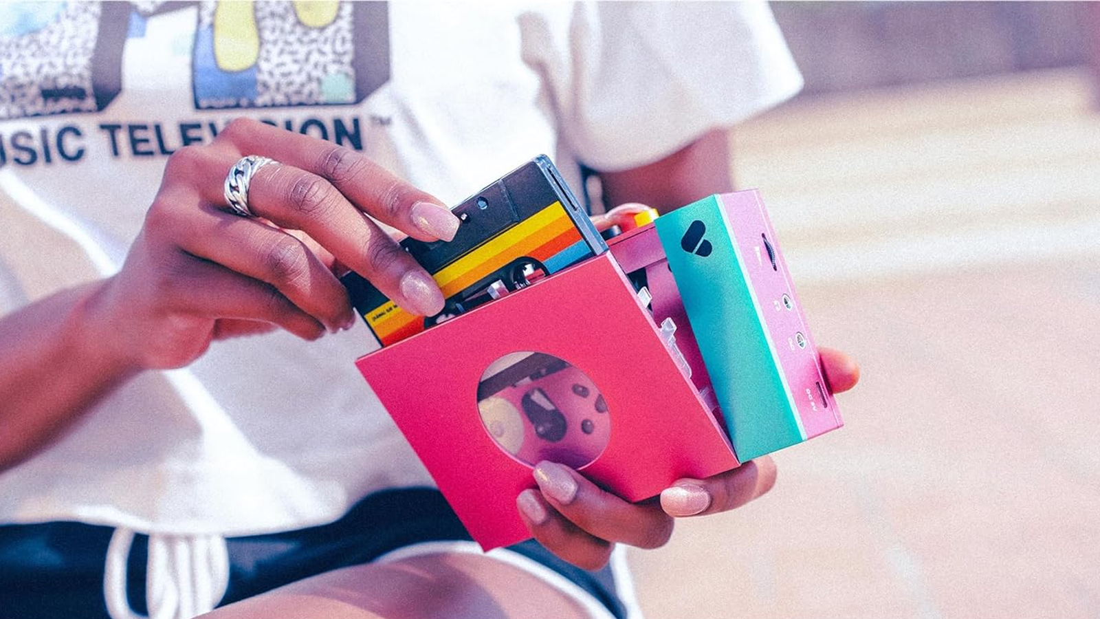 A person puts a tape into a cassette player