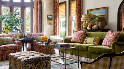 living space with green sofa floral textiles animal print ottoman checked armchair fabric and lampshade curved bay window and red floral curtains