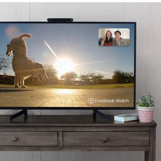 video call on a tv with a jumpingdog on screen and a man and woman watching