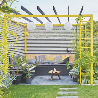 yellow pergola over a seating area and fire pit