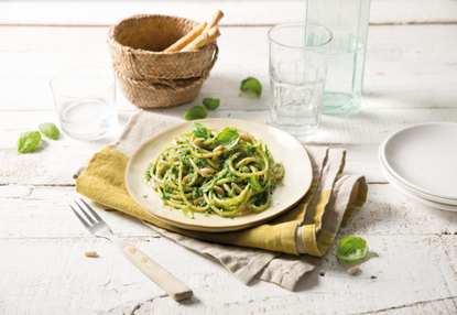 spaghetti with pesto and pine nuts on plate