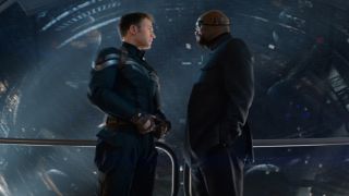 Chris Evans and Samuel L Jackson stand talking in front of a massive helicarrier in Captain America: The Winter Soldier.