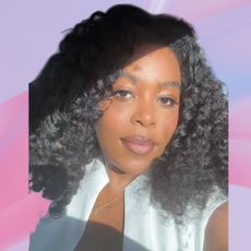 An image of ariel baker surrounded by cyklar perfume oil and bvlgari fragrance magnifier. Set against a purple backdrop white pink fabric swriling behind her head.