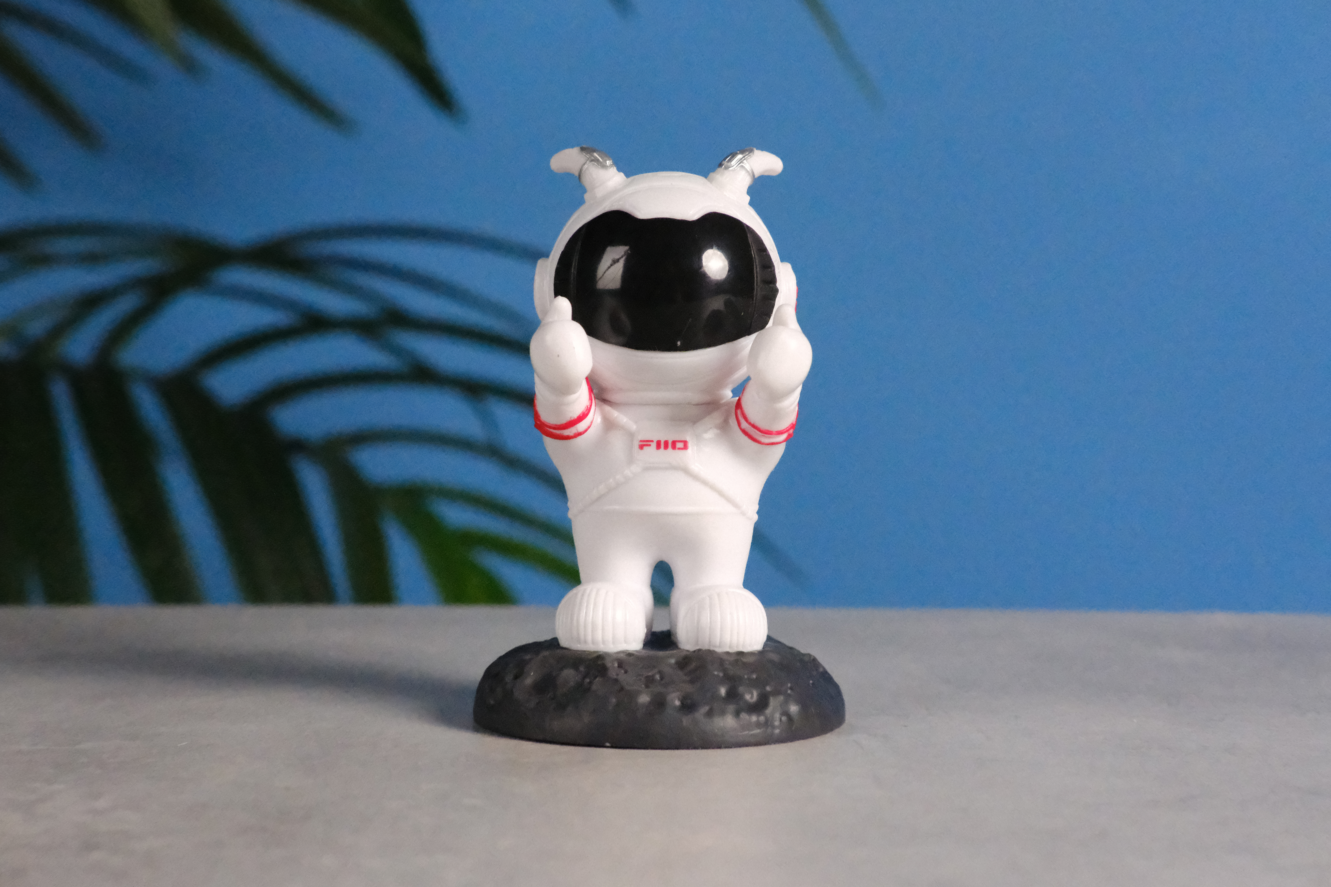 A photo of an astronaut toy against a blue background, taken on the Fujifilm X-E5